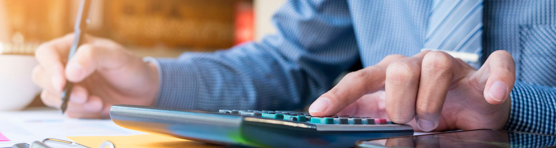 homem digitando em uma calculadora