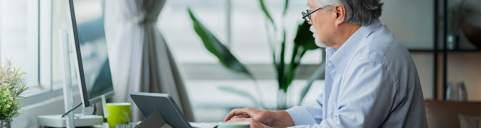 imagem de um homem de perfil na frente do computador ele está lendo como abrir uma corretora de seguros