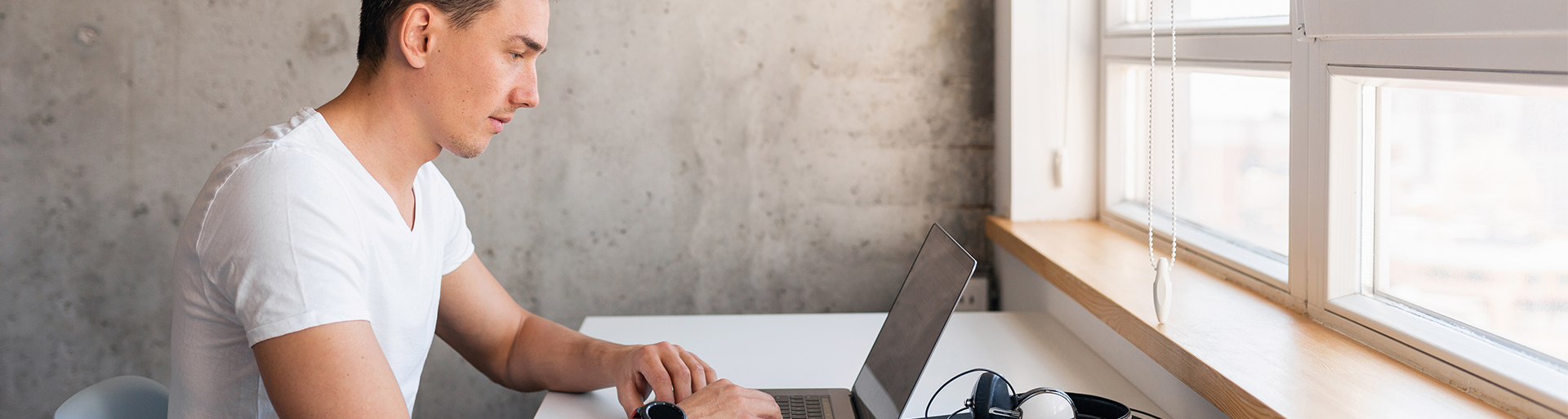 homem na frente do notebook pesquisando sobre investir em franquias